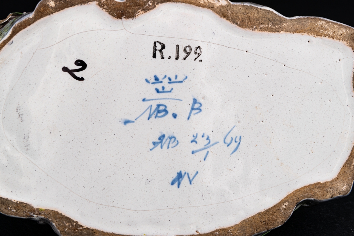 Smörask, fajans, locket med liggane manlig herde och get.
Märkt NB,23/1 69.