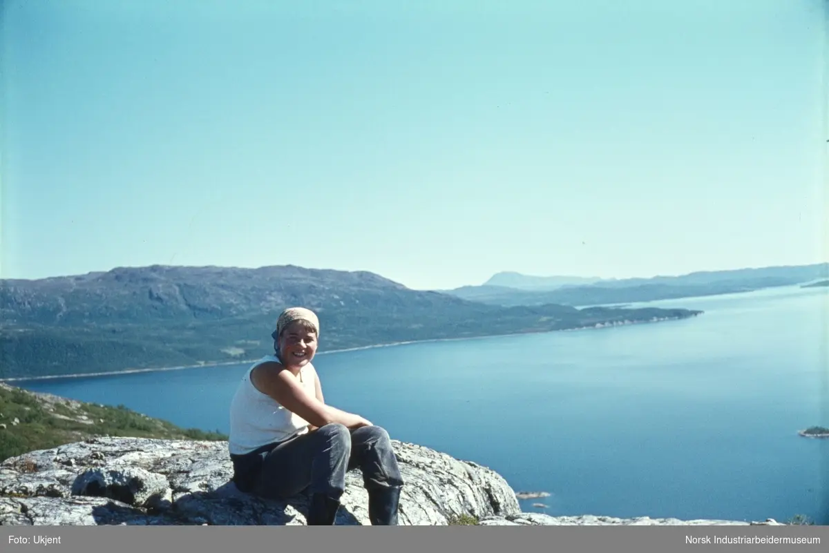 Anne Dyrland sitter i fjellet ovenfor Hamaren med utsikt over innsjøen Møsvatn