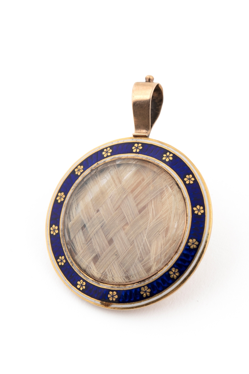 Medaljong med flettet hår og tørkede blomster inni.