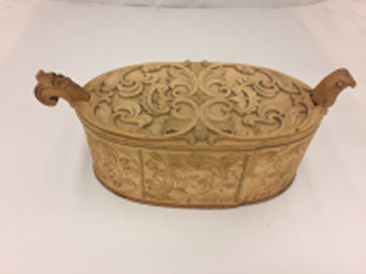 Sveipa, oval tine med utskjeringar. Flat, innrissa skurd på sjølve asken. Loket har også utskjeringar. C-krullar, blad, sirkelformer m.m. Bokstavane  (?) L S 1803 er skore inn. Eit "øyre" på kvar side av tina.