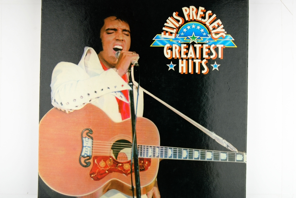 Bilde av Elvis Presley. Synger og har en gitar rundt livet.