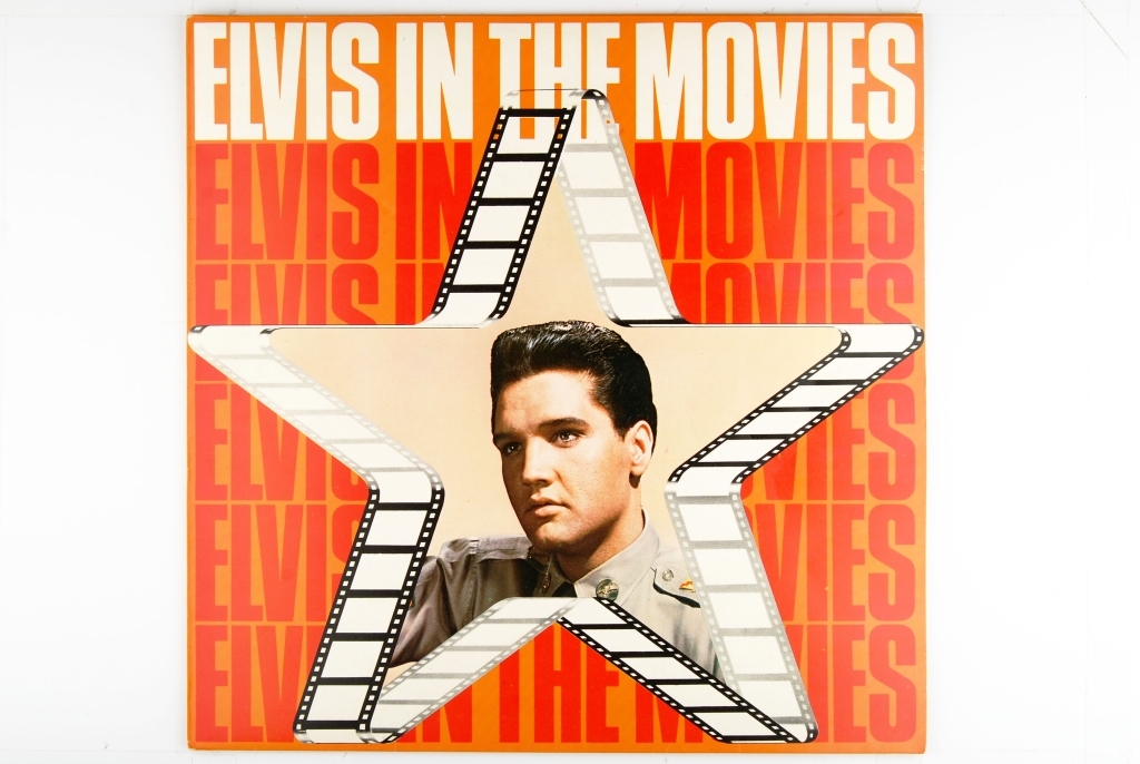 Bilde av Elvis Presley. Synger og har en gitar rundt livet.