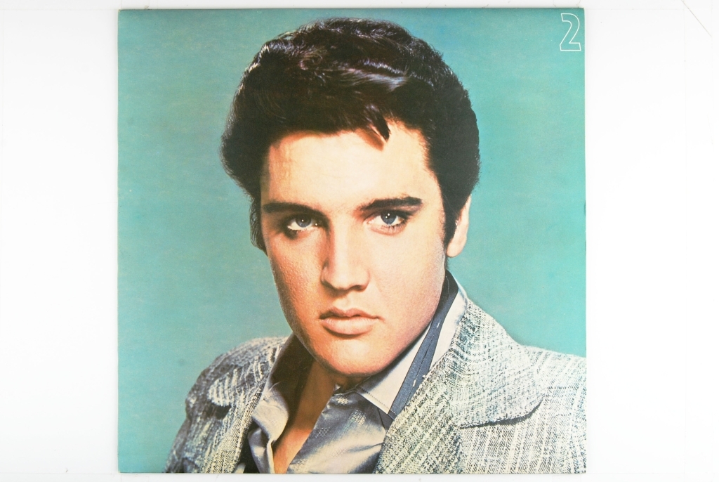 Bilde av Elvis Presley. Synger og har en gitar rundt livet.