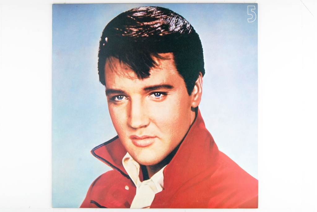 Bilde av Elvis Presley. Synger og har en gitar rundt livet.
