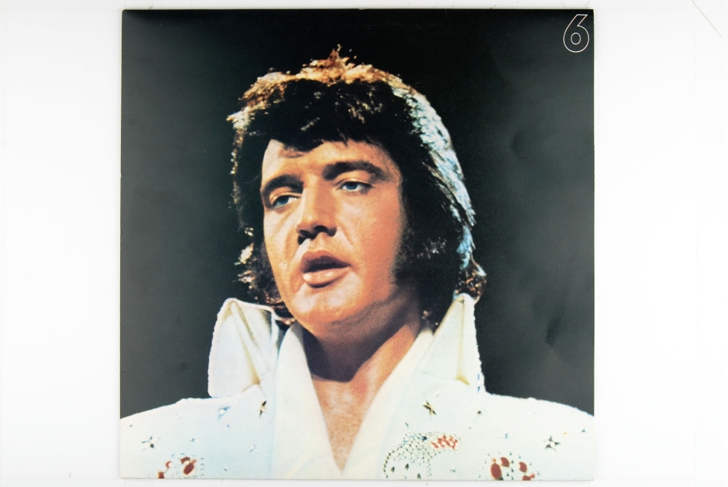 Bilde av Elvis Presley. Synger og har en gitar rundt livet.