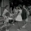 Tennisfinaler och prisutdelning en måndag. Människor vid en byggnad under sommartid.