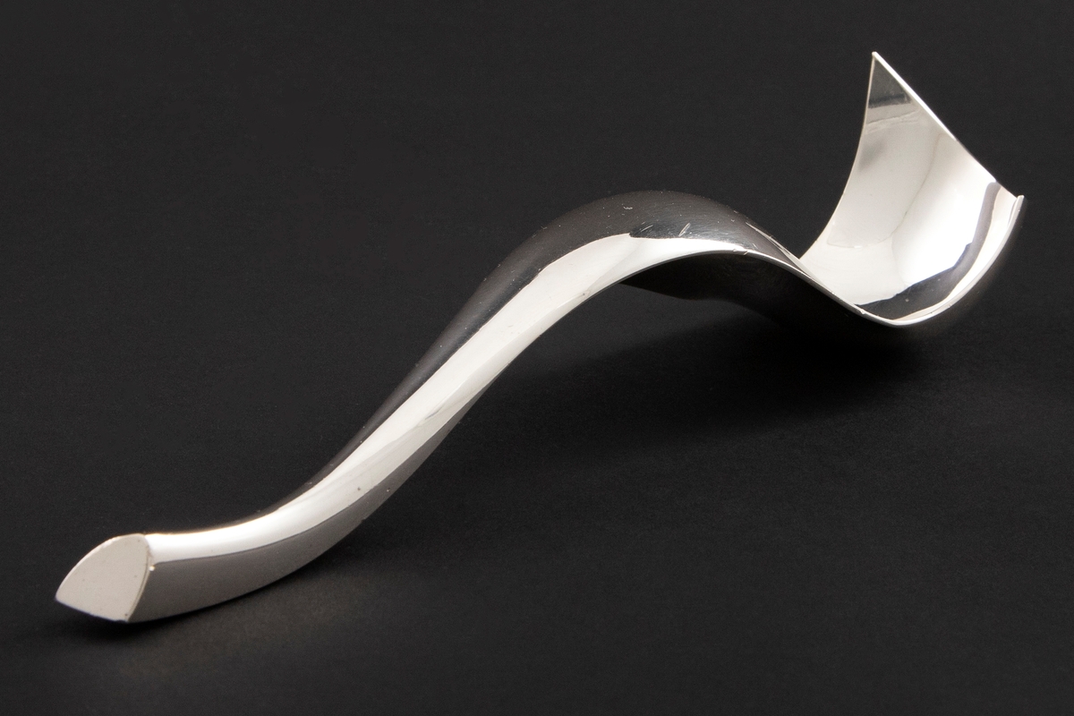 Formprøve med skulpturelt utrykk i forsølvet metall. Organisk formspråk, hvor man veksler mellom konvekse og konkave former.