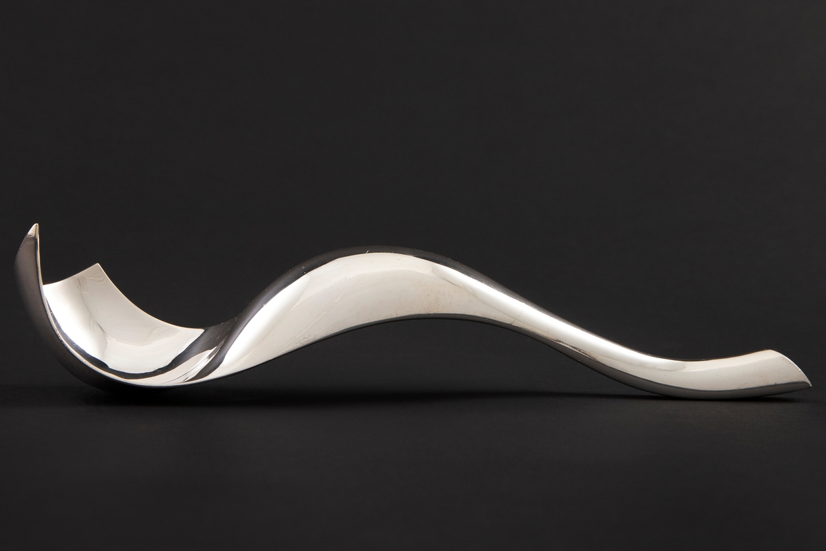 Formprøve med skulpturelt utrykk i forsølvet metall. Organisk formspråk, hvor man veksler mellom konvekse og konkave former.