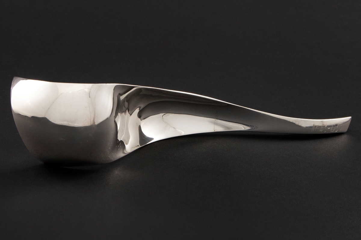 Formprøve med skulpturelt utrykk i forsølvet metall. Organisk formspråk, hvor man veksler mellom konvekse og konkave former.