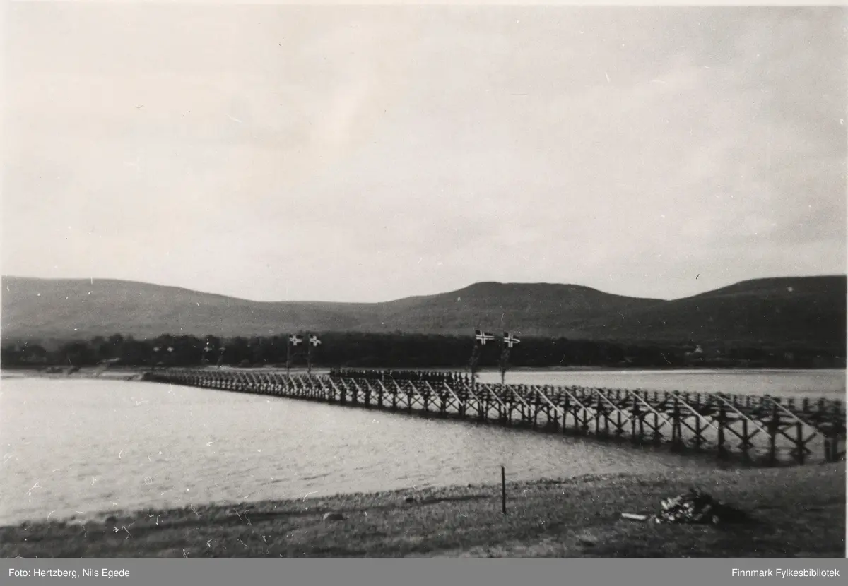 Bruen over Tanaelva i Seida, 1939. I 1939 ble det bygd en bukkebru over Tanaelva, denne lå i Seida og bestod av trebukker. Midt på bruen står en tropp fra det militæret å skyter geværsalver i forbindelse med åpningen av den nye bruen.