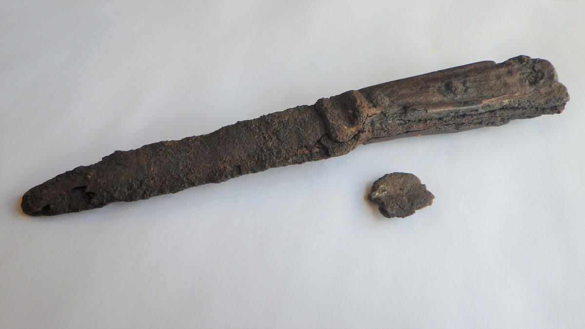 Kniv av jern med beinskaft som er naglet fast.