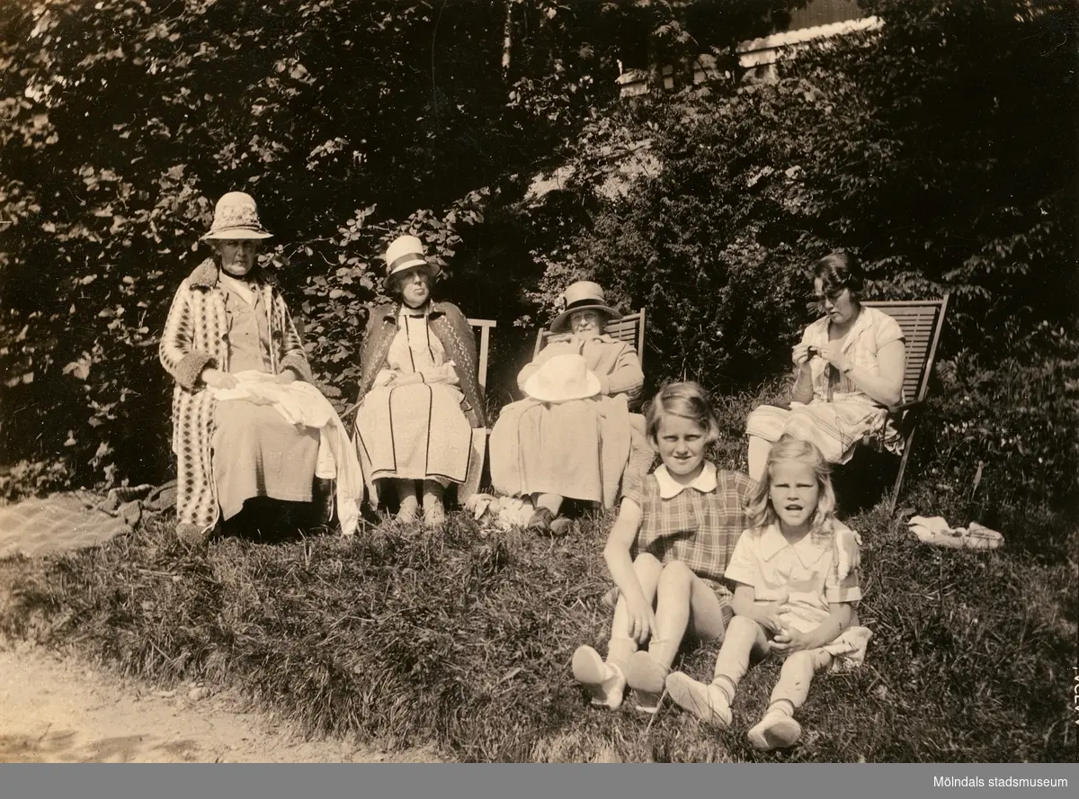 Laila Björck i solstol till höger samt hennes mostrar. Flickorna som sitter på marken är Lailas döttrar, Ulla till vänster, samt Bibbi till höger.

Fotografi taget i juni 1929 vid sommarbostaden Strandlyckan vid Landvettersjön, Slamby 1:4 i Landvetter socken. Huset övertogs senare av Stiftelsen Enandergården, Härlanda församling, på 1950-talet.