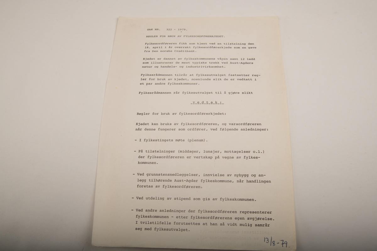 Et stort halskjede med et bånd bestående av brede, flate plater som overlapper annenhver på oversiden og undersiden. Med unntak av skrift på platen helt bakerst er kjedet helt symmetrisk. I midten foran er Fylkeskomummens Aust-Agders våpenskjold, et skjold med to gylne striper over rød bakgrunn. Hver plate har et motiv og to av dem, en på hver side, har satt inn steiner, en grønnspettet stein og en spettet rødrosa stein. En tynnere lenke er festet på tvers på midten av kjedet.