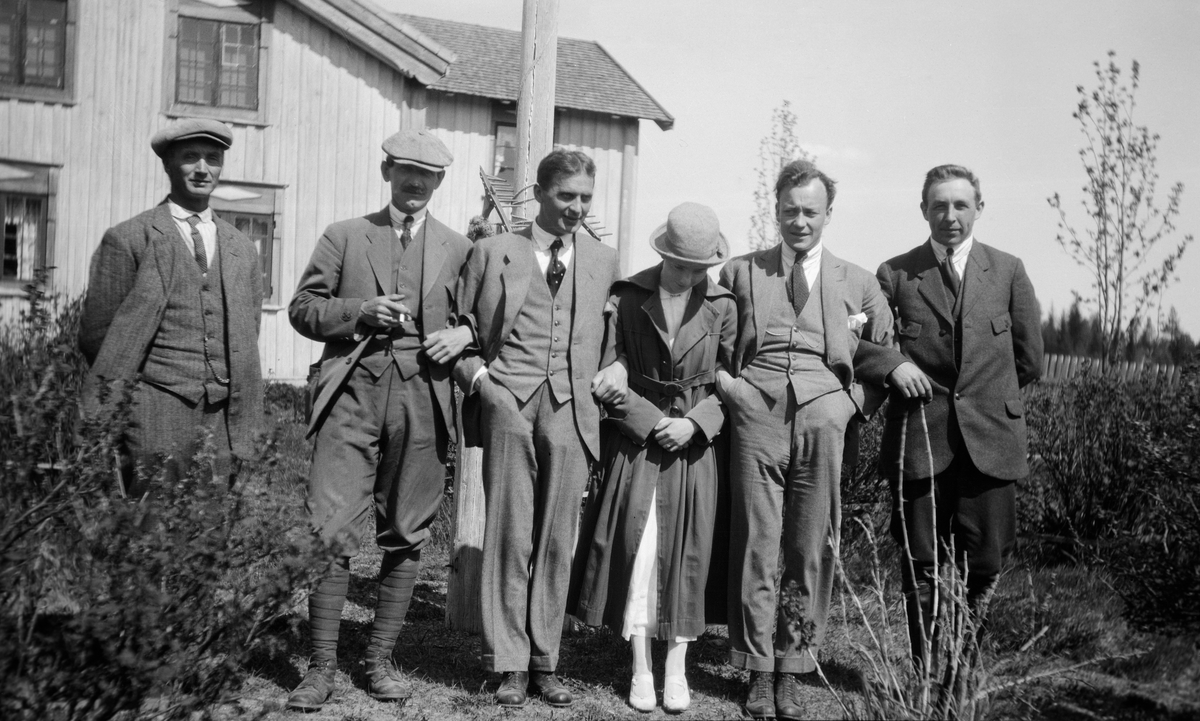 Gruppe med fem menn og ei dame utenfor våningshuset på Brevik ved Valmen i Nordre Osen (Åmot, Hedmark) i 1919.  Brevik var skysstasjon med en viss overnattingskapasitet.  Mennene var iført dresser, hvite skjorte og slips, mens dama var kledd i hvit kjole, overtrekksfrakk og hatt med moteriktig rund pull. Draktene indikerer at dette ikke er lokale arbeidsfolk, men heller tilreisende representanter for fløtingsadministrasjonen. Det er nærliggende å tenke seg at fotografiet må være tatt i forbindelse med at styret for Christiania Tømmerdirektion var på sin årlige befaring langs vassdraget, men vi har foreløpig ingen navn på de avbildete personene. I 1919 besto direksjonen av godseier Westye Parr Egeberg og dispnent Halfdan Mathiesen, som representerte «Kristiania-distriktet», konsul Emil Mørch og disponent Otto Nilsen fra Fredrikstad-distriktet, grosserer Albert Asbjørnsen og konsul Math. Smith fra Sarpsborg-distriktet, skog- og sagbrukseier Børre Vik fra Mjøsegnene og cand. jur. Amund Bredesen Opset og skogeier Olav Nergård fra Glommadalføret. Hvert distrikt hadde også en «supleant» (vararepresentant), men det er uklart i hvilken grad disse deltok i befaringene.

1919 var et spesielt år i Glommafløtingas historie i den forstand at generalforsamlinga i Christiania Tømmerdirektion (Øvre Glommens fællesfløtningsforening) vedtok at de lokale skogeiernes åstyrer, som hadde ansvar for å få tømmeret gjennom tverrelvene, skulle få bli medlemmer av Tømmerdirektionen. Åstyrene skulle likevel fortsette å administrere fløtinga i sine tverrelver, men blant skogeierne i Østerdalen utløste dette forventninger om at Tømmerdirektionen ville utvide de elvestrekningene der de organiserte og finansierte fløtinga. Derfor bad skogeierne Tømmerdirektionen - styremedlemmene - om å legge sin årlige befaring til Østerdalen dette året. På Osensjøen fikk ikke såkalt «kjøpmannsfløting» før i 1942.