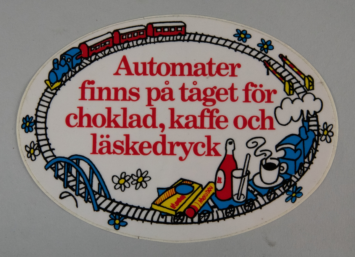 Oval klisterdekal med texten "Automater finns på tåget för choklad, kaffe och läskedryck" med rött i mitten. Runtom texten går en räls med ett persontåg, nedfällda vägbommar, blommor, en bro samt ett godståg med en kaffekopp, en läskedrycksflaska och ett glas med ett sugrör i samt en chokladkaka och en cylinderformad chokladförpackning med texten "Marabou" på.
På skyddspappret sitter en dekal som talar om att det är ett tryckprov och ett materialprov samt skyddsfolierad vinylfolie av Form Litho.