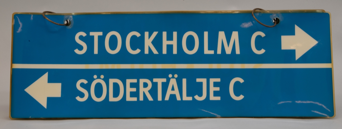 Destinationsskyltar för X1, rektangulära skyltar av tunn plast på två metallringar. Det är sex stycken olika skyltar med blå botten och vit text på båda sidor. På skyltarna står olika destinationer och ibland åkriktningar.