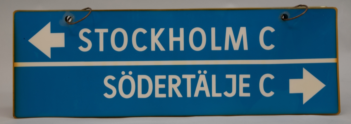Destinationsskyltar för X1, rektangulära skyltar av tunn plast på två metallringar. Det är sex stycken olika skyltar med blå botten och vit text på båda sidor. På skyltarna står olika destinationer och ibland åkriktningar.