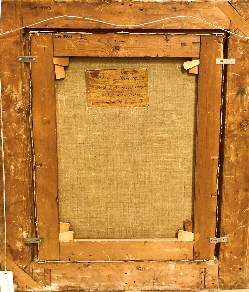 Porträtt med ram. Oljemålning på duk. Förgylld träram med riklig ornamentik. Bröstbild framifrån, fas höger, föreställande Anders Garberg i blå dubbelknäppt rock med släta mässingsknappar och hög krage. Vitt om halsen samt dito fluga. Brunt hår och långa polisonger.