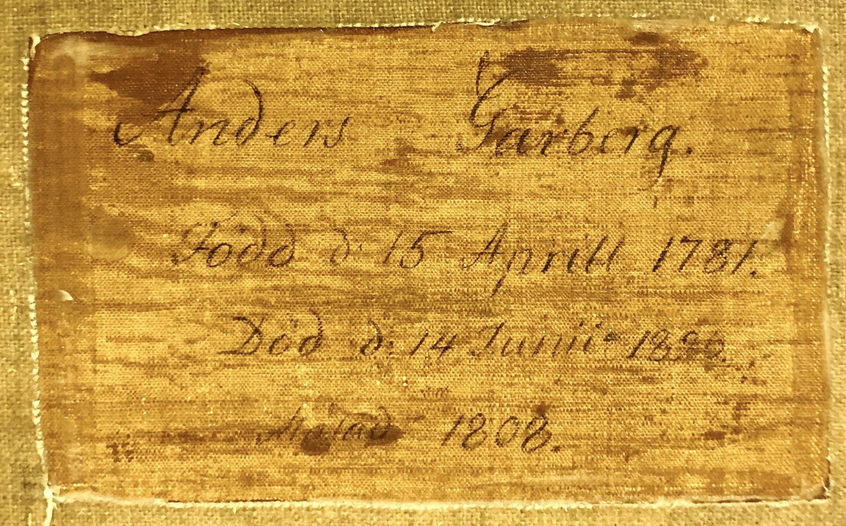 Porträtt med ram. Oljemålning på duk. Förgylld träram med riklig ornamentik. Bröstbild framifrån, fas höger, föreställande Anders Garberg i blå dubbelknäppt rock med släta mässingsknappar och hög krage. Vitt om halsen samt dito fluga. Brunt hår och långa polisonger.