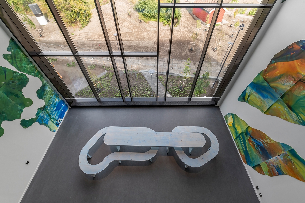 Kunstneren inntar rommets tre vegger med et monumentalt maleri. På gulvet står tremøblet The Loop. Det åpne rommet går i dialog med arkitekturen innover i bygningen og med utsikten over parken. Kunstverket er synlig fra utsiden, akkurat som veggmaleriet til Anders Smebye på Veterinærinstituttet, og begge verkene deler de tematiske berøringspunktene vann og økologi. De landskapslignende formene i maleriet er arbeidet frem vått i vått på liggende plater til en organisk og flytende helhet. De to benkene bukter seg gjentakende rundt bordet som ringer i vann.

Bakgrunnen for kunstverket er kunstnerens opplevelse av familiens oversvømte risåkrer i hjemlandet Thailand, en erfaring hun stadig bruker som utgangspunkt i sin kunst. Maleriet er en personlig refleksjon over et alvorlig tema: lokale konsekvenser av klimaendringer og verdenssamfunnets ansvar for og håndtering av naturkatastrofer.

The Loop er laget i samarbeid med arkitekt Cristian Stefanescu.