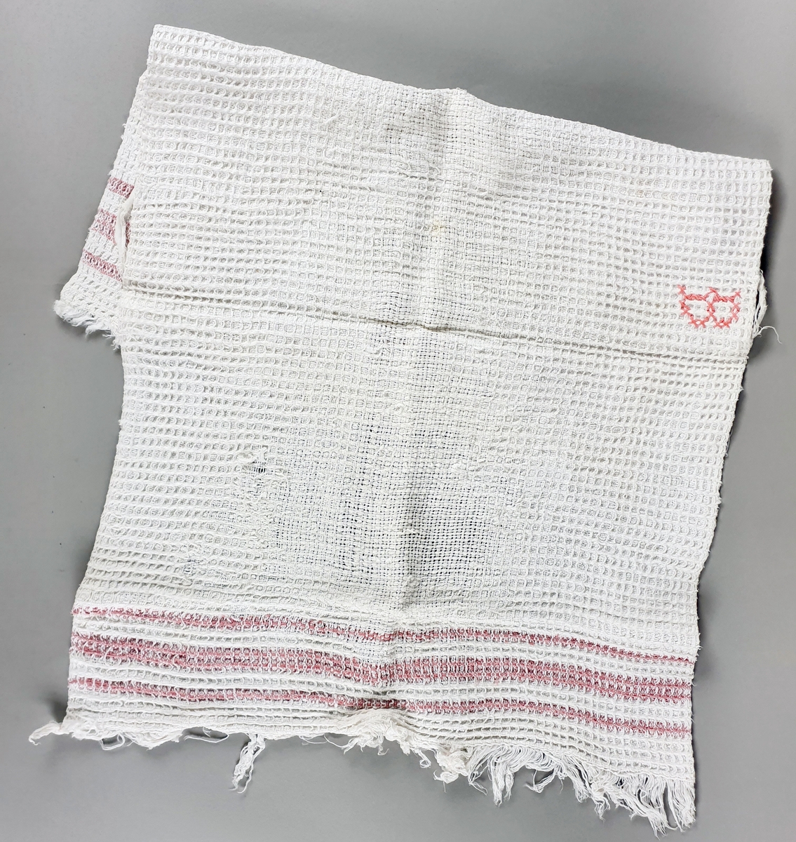 To hvite håndklær av bomull med røde striper på hver kortside. Brodert bokstav - B - på midten av den ene langsiden.