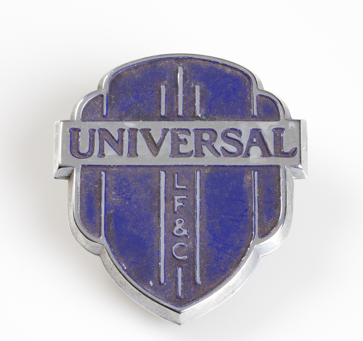 Emblem. Varumärke "UNIVERSAL LF & C”, ett företag som sålde hushållsartiklar såsom aluminiumgrytor, bestick, korkskruvar och burköppnare mm. Företaget startade 1865 av Landers, Frary & Clark i New Britain, Connecticut och såldes till General Electric Company 1965.