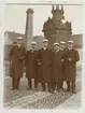 Sex män, Harald Falk tvåa från vänster, iklädda studentmössor och rock, vid Sankt Eriks brunn, Uppsala omkring 1900