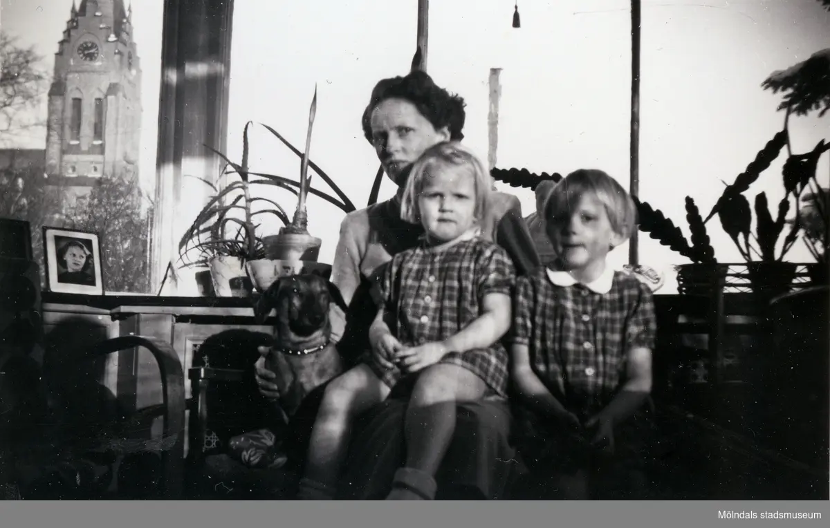 Mamma Ulla tillsammans med sina flickor, Angelica (född 1951) till vänster och Susanne (född 1950) till höger, samt en hund i inneverandan till Dr Björcks villa, Villa Björkås, i Åby, Mölndal, julen 1954-1955.

Numera har huset adressen Frölundagatan 25 B i Åby, Mölndal.