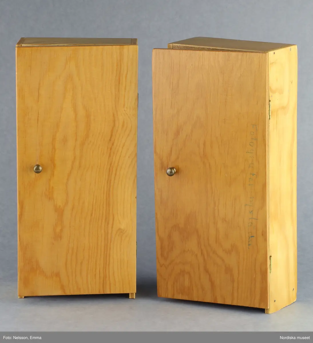 Inventering Sesam 1996-1999:
B 77,5, Djup 36,0, H 119,0 cm
Dockskåp av furu med mellanväggar av plywood, målat i gräddgult, fasaden "putsad" med färg blandad med sågspån. Dockskåpet har dubbeldörrar med lås och en fasad på gångjärn med en dörr och 10 fönster, inspirerad av det första kollektivhuset i funkisstil på John Erikssons gata. Dockskåpet är befolkat av fam. Björnerholm. Gunvor Svartz-Malmberg f. 1925-6 var ca 10 år när hon fick skåpet. 
LS 85
Helena Carlsson