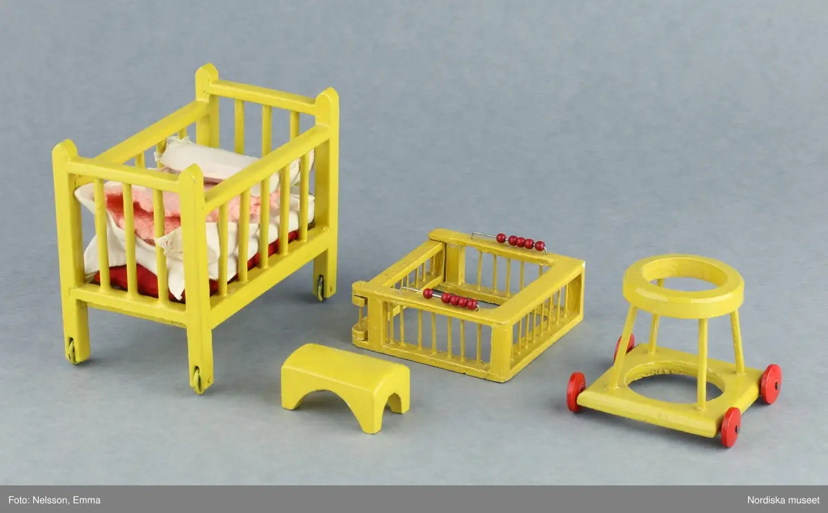 Inventering Sesam 1996-1999:
B 77,5, Djup 36,0, H 119,0 cm
Dockskåp av furu med mellanväggar av plywood, målat i gräddgult, fasaden "putsad" med färg blandad med sågspån. Dockskåpet har dubbeldörrar med lås och en fasad på gångjärn med en dörr och 10 fönster, inspirerad av det första kollektivhuset i funkisstil på John Erikssons gata. Dockskåpet är befolkat av fam. Björnerholm. Gunvor Svartz-Malmberg f. 1925-6 var ca 10 år när hon fick skåpet. 
LS 85
Helena Carlsson