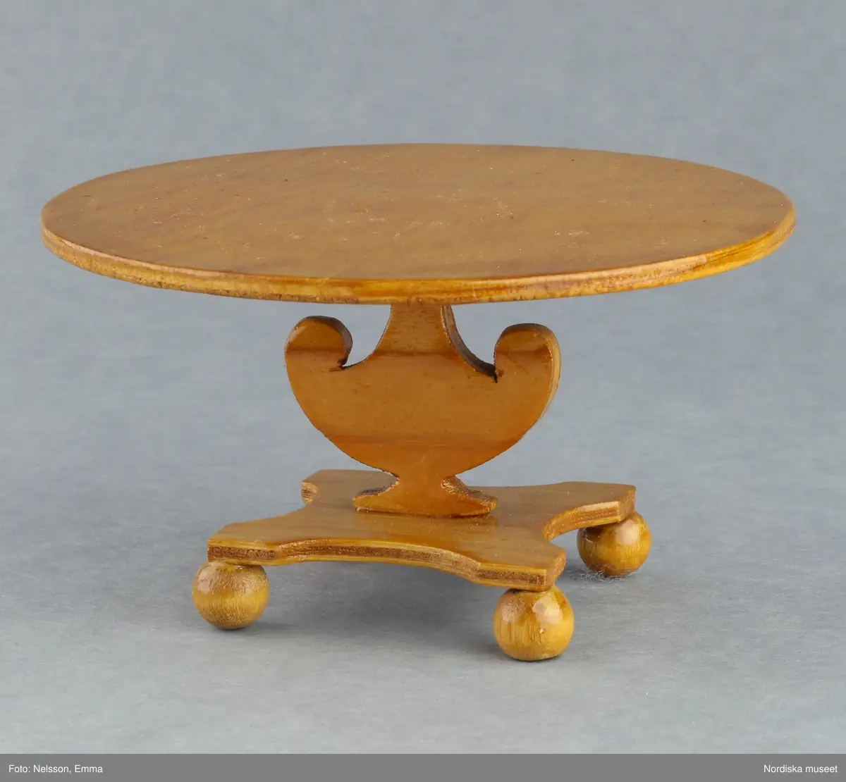Inventering Sesam 1996-1999:
B 77,5, Djup 36,0, H 119,0 cm
Dockskåp av furu med mellanväggar av plywood, målat i gräddgult, fasaden "putsad" med färg blandad med sågspån. Dockskåpet har dubbeldörrar med lås och en fasad på gångjärn med en dörr och 10 fönster, inspirerad av det första kollektivhuset i funkisstil på John Erikssons gata. Dockskåpet är befolkat av fam. Björnerholm. Gunvor Svartz-Malmberg f. 1925-6 var ca 10 år när hon fick skåpet. 
LS 85
Helena Carlsson