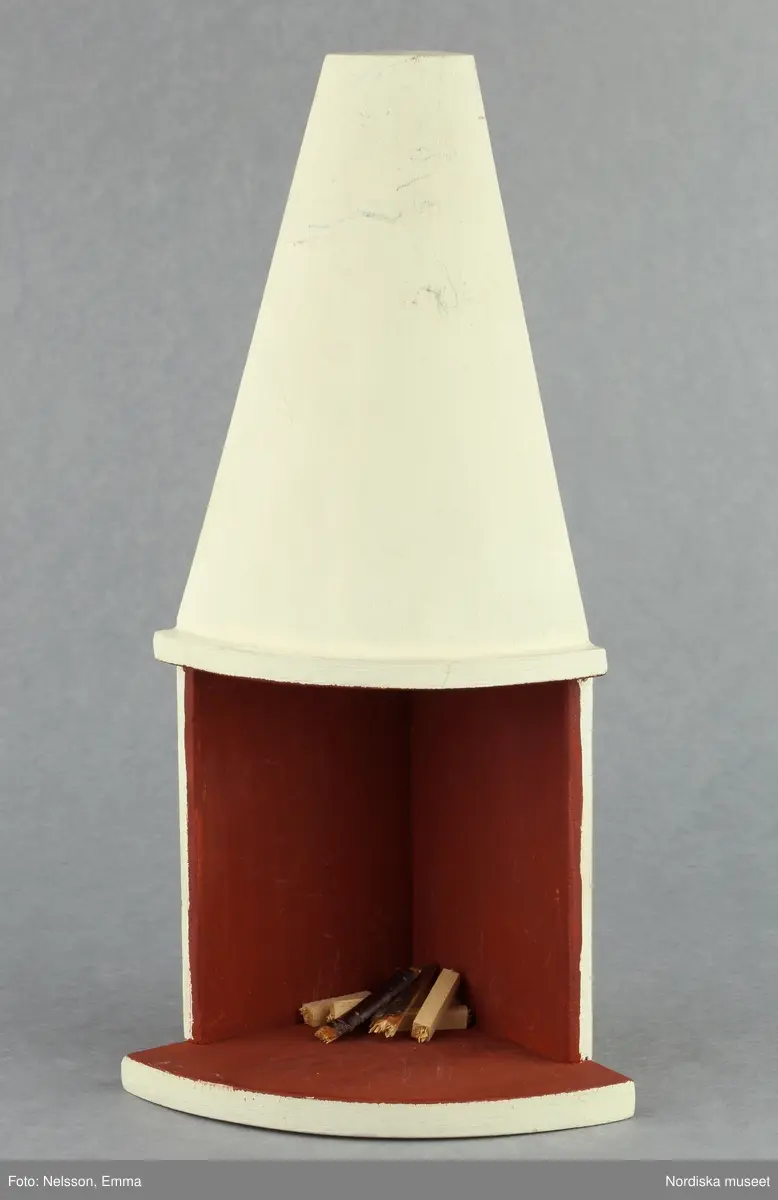 Inventering Sesam 1996-1999:
B 77,5, Djup 36,0, H 119,0 cm
Dockskåp av furu med mellanväggar av plywood, målat i gräddgult, fasaden "putsad" med färg blandad med sågspån. Dockskåpet har dubbeldörrar med lås och en fasad på gångjärn med en dörr och 10 fönster, inspirerad av det första kollektivhuset i funkisstil på John Erikssons gata. Dockskåpet är befolkat av fam. Björnerholm. Gunvor Svartz-Malmberg f. 1925-6 var ca 10 år när hon fick skåpet. 
LS 85
Helena Carlsson