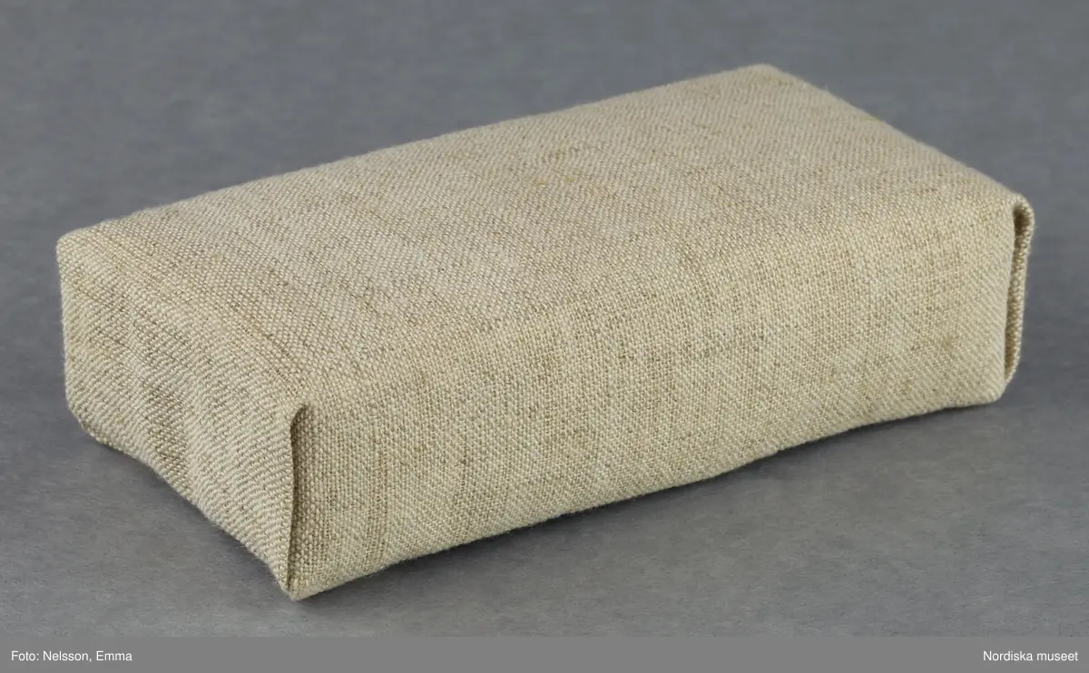 Inventering Sesam 1996-1999:
B 77,5, Djup 36,0, H 119,0 cm
Dockskåp av furu med mellanväggar av plywood, målat i gräddgult, fasaden "putsad" med färg blandad med sågspån. Dockskåpet har dubbeldörrar med lås och en fasad på gångjärn med en dörr och 10 fönster, inspirerad av det första kollektivhuset i funkisstil på John Erikssons gata. Dockskåpet är befolkat av fam. Björnerholm. Gunvor Svartz-Malmberg f. 1925-6 var ca 10 år när hon fick skåpet. 
LS 85
Helena Carlsson