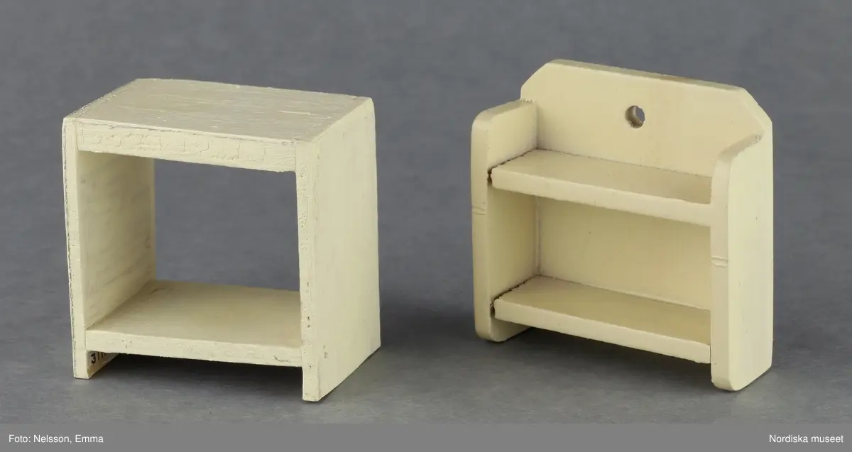 Inventering Sesam 1996-1999:
B 77,5, Djup 36,0, H 119,0 cm
Dockskåp av furu med mellanväggar av plywood, målat i gräddgult, fasaden "putsad" med färg blandad med sågspån. Dockskåpet har dubbeldörrar med lås och en fasad på gångjärn med en dörr och 10 fönster, inspirerad av det första kollektivhuset i funkisstil på John Erikssons gata. Dockskåpet är befolkat av fam. Björnerholm. Gunvor Svartz-Malmberg f. 1925-6 var ca 10 år när hon fick skåpet. 
LS 85
Helena Carlsson