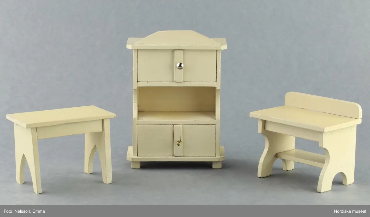 Inventering Sesam 1996-1999:
B 77,5, Djup 36,0, H 119,0 cm
Dockskåp av furu med mellanväggar av plywood, målat i gräddgult, fasaden "putsad" med färg blandad med sågspån. Dockskåpet har dubbeldörrar med lås och en fasad på gångjärn med en dörr och 10 fönster, inspirerad av det första kollektivhuset i funkisstil på John Erikssons gata. Dockskåpet är befolkat av fam. Björnerholm. Gunvor Svartz-Malmberg f. 1925-6 var ca 10 år när hon fick skåpet. 
LS 85
Helena Carlsson