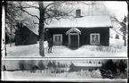 Pojke på skidor framför hus