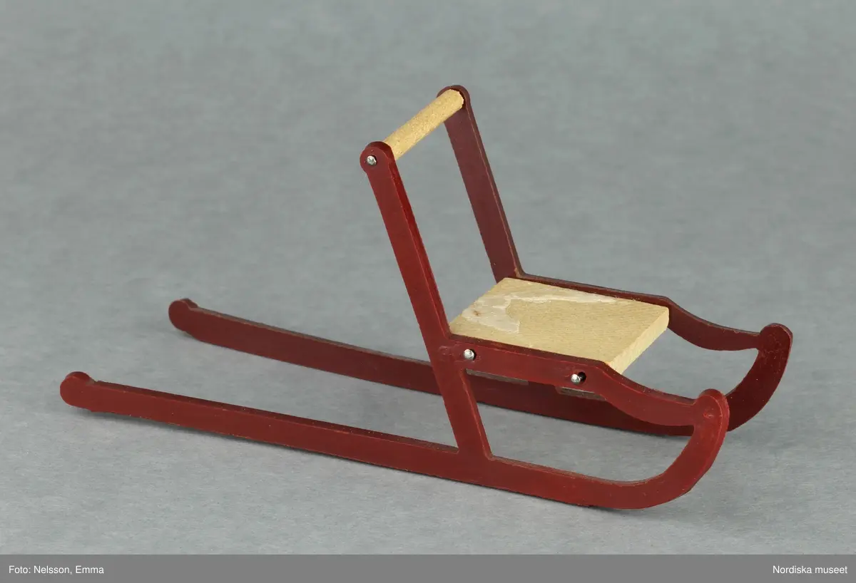 Inventering Sesam 1996-1999:
B 77,5, Djup 36,0, H 119,0 cm
Dockskåp av furu med mellanväggar av plywood, målat i gräddgult, fasaden "putsad" med färg blandad med sågspån. Dockskåpet har dubbeldörrar med lås och en fasad på gångjärn med en dörr och 10 fönster, inspirerad av det första kollektivhuset i funkisstil på John Erikssons gata. Dockskåpet är befolkat av fam. Björnerholm. Gunvor Svartz-Malmberg f. 1925-6 var ca 10 år när hon fick skåpet. 
LS 85
Helena Carlsson
