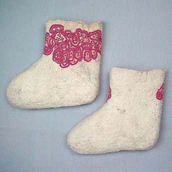 Sockar tovade av naturvit ull, Troligtvis ryaull. Sockarna har en naturligt avslutad kant. Broderimönster med 2-trådigt ullgarn på utsidan av skaften i cerisrosa kedjesömsslingor, gula och gammelrosa knutsömsblommor och röda öglesömsblommor. Vänstra sockan märkt storlek 35.