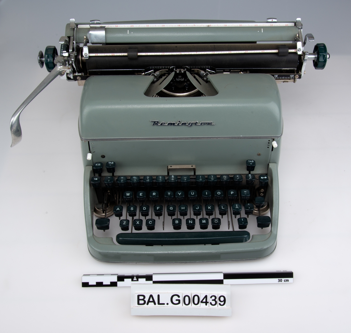 Gjenstandens tangener er mørk-grønn mot sort, med hvite tegn.
Gjenstandens hovedfarge er grå mot lys grønn.
Papirholder/trommel er sort.
Enkelte detaljer er i blankt metall.
Produsentmerke i metall "Remington" mellom tangenter og skrivehode/papirholder.