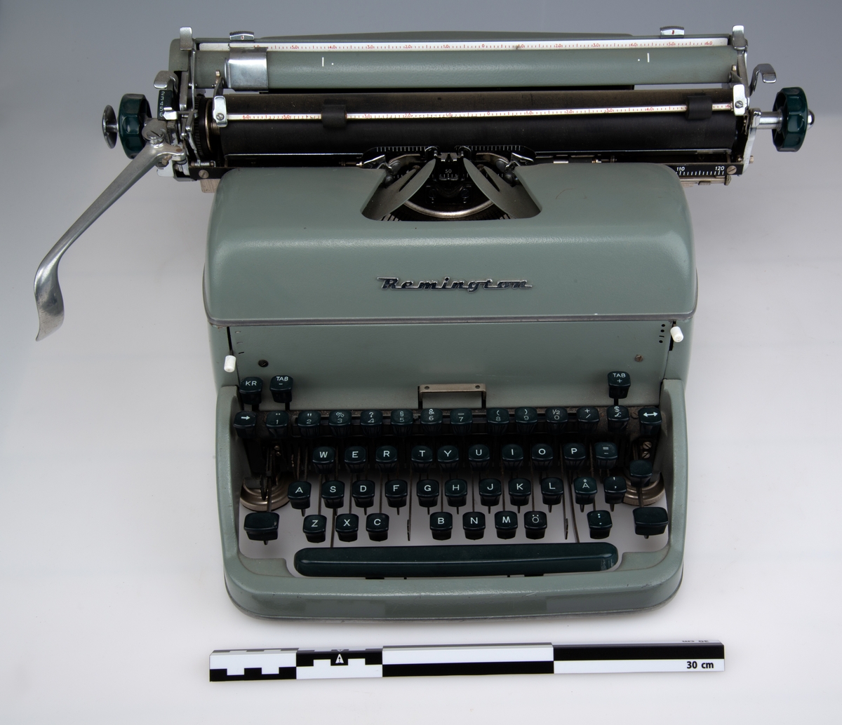 Gjenstandens tangener er mørk-grønn mot sort, med hvite tegn.
Gjenstandens hovedfarge er grå mot lys grønn.
Papirholder/trommel er sort.
Enkelte detaljer er i blankt metall.
Produsentmerke i metall "Remington" mellom tangenter og skrivehode/papirholder.