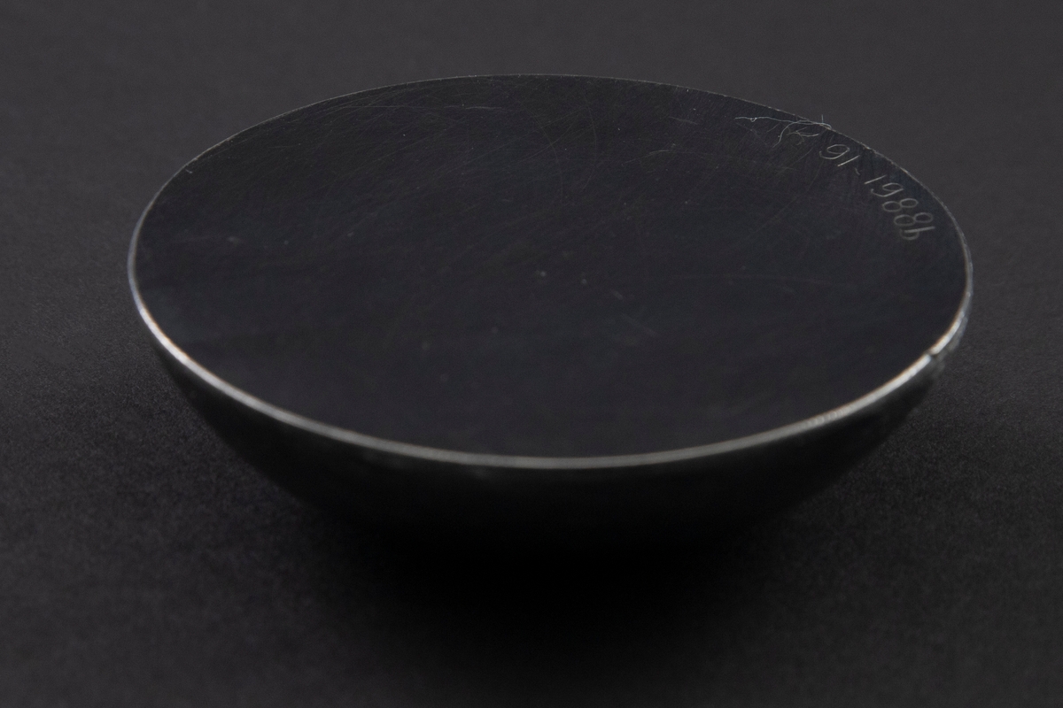 Halvkuleformet lokk i oksidert sølv.