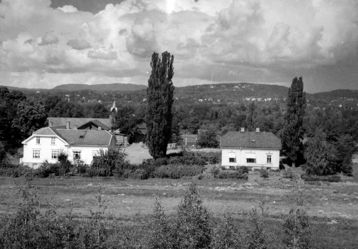 Tunet med bolighus på Bygdø Kongsgård. Fra venstre forvalterboligen og gårdsfullmektigboligen. Fjøset med klokketårn i bakgrunnen. Fotografert ca. 1960.