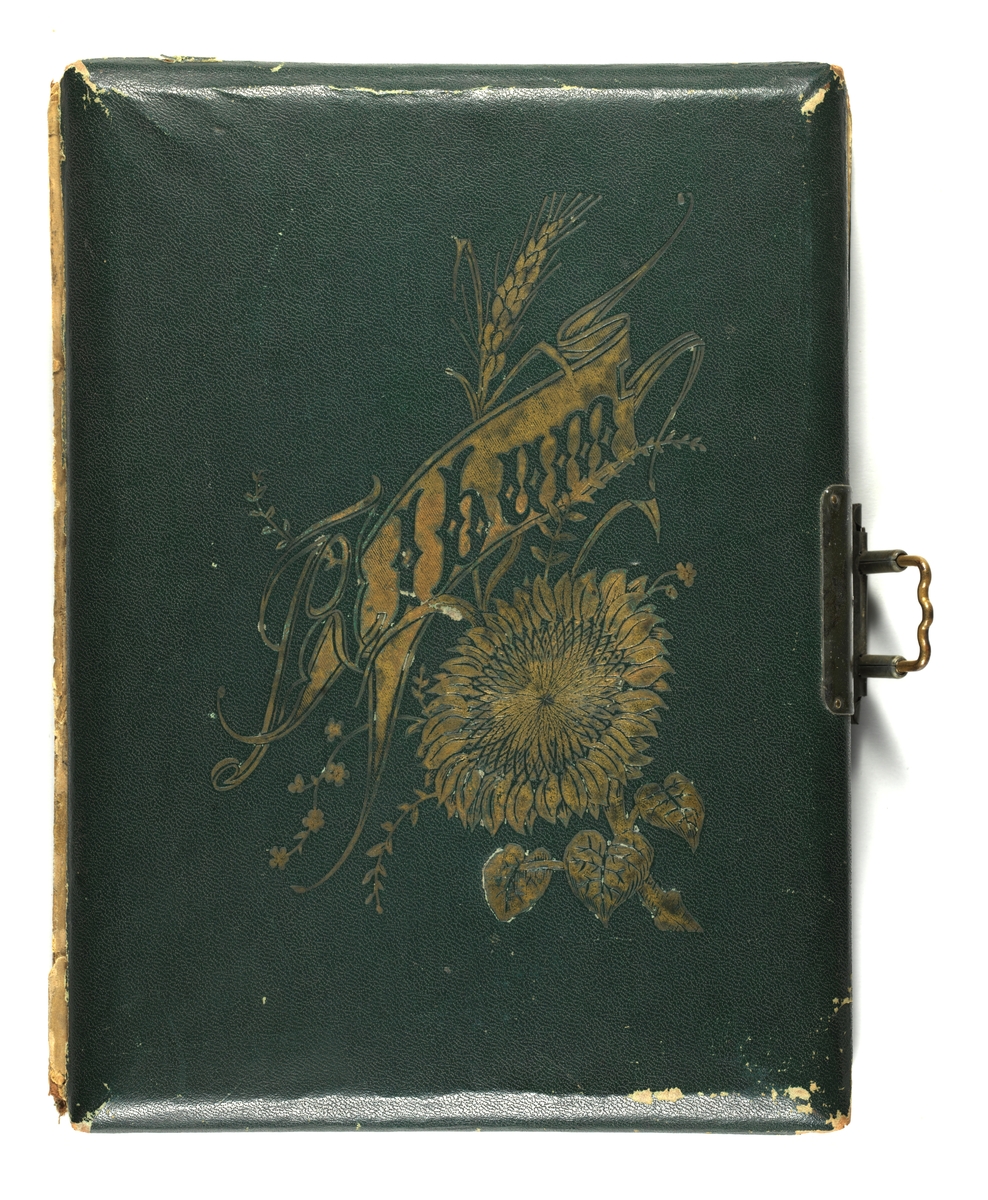 Svarthvitt-fotos i album med mørkegrønn skinnimitert perm og metallspenne.
