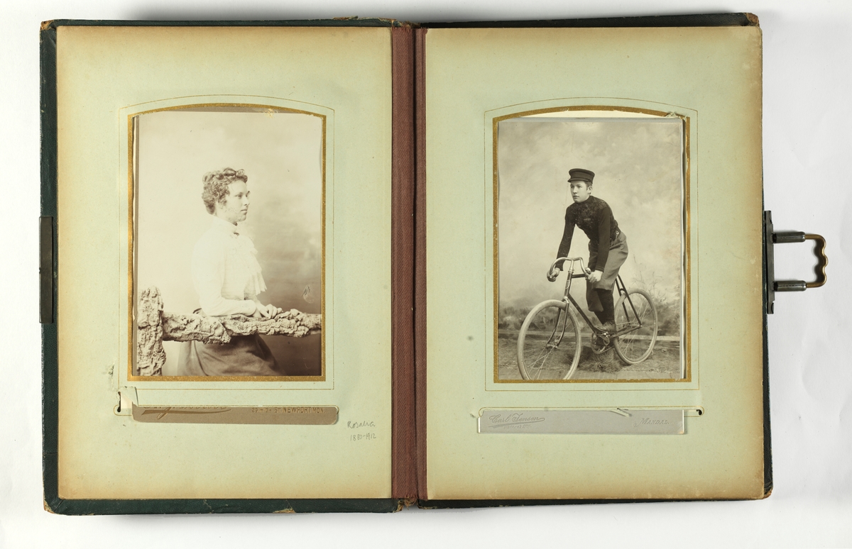 Svarthvitt-fotos i album med mørkegrønn skinnimitert perm og metallspenne.