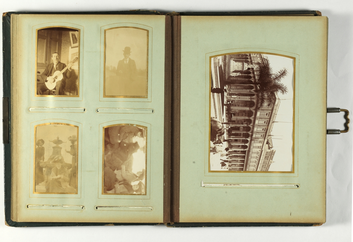 Svarthvitt-fotos i album med mørkegrønn skinnimitert perm og metallspenne.