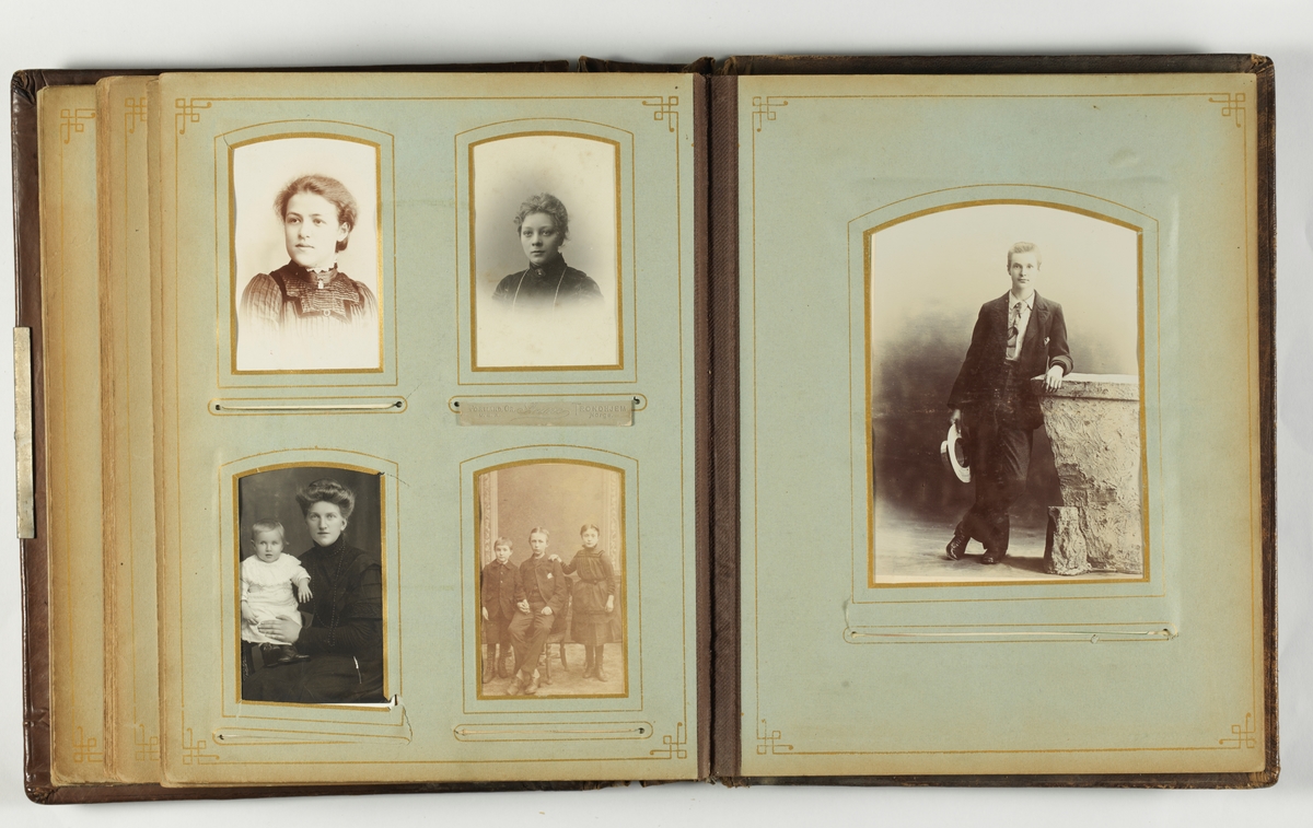 Gulnete svarthvitt-fotos i album med brun skinnperm med presset dekor.
Perm løsnet.