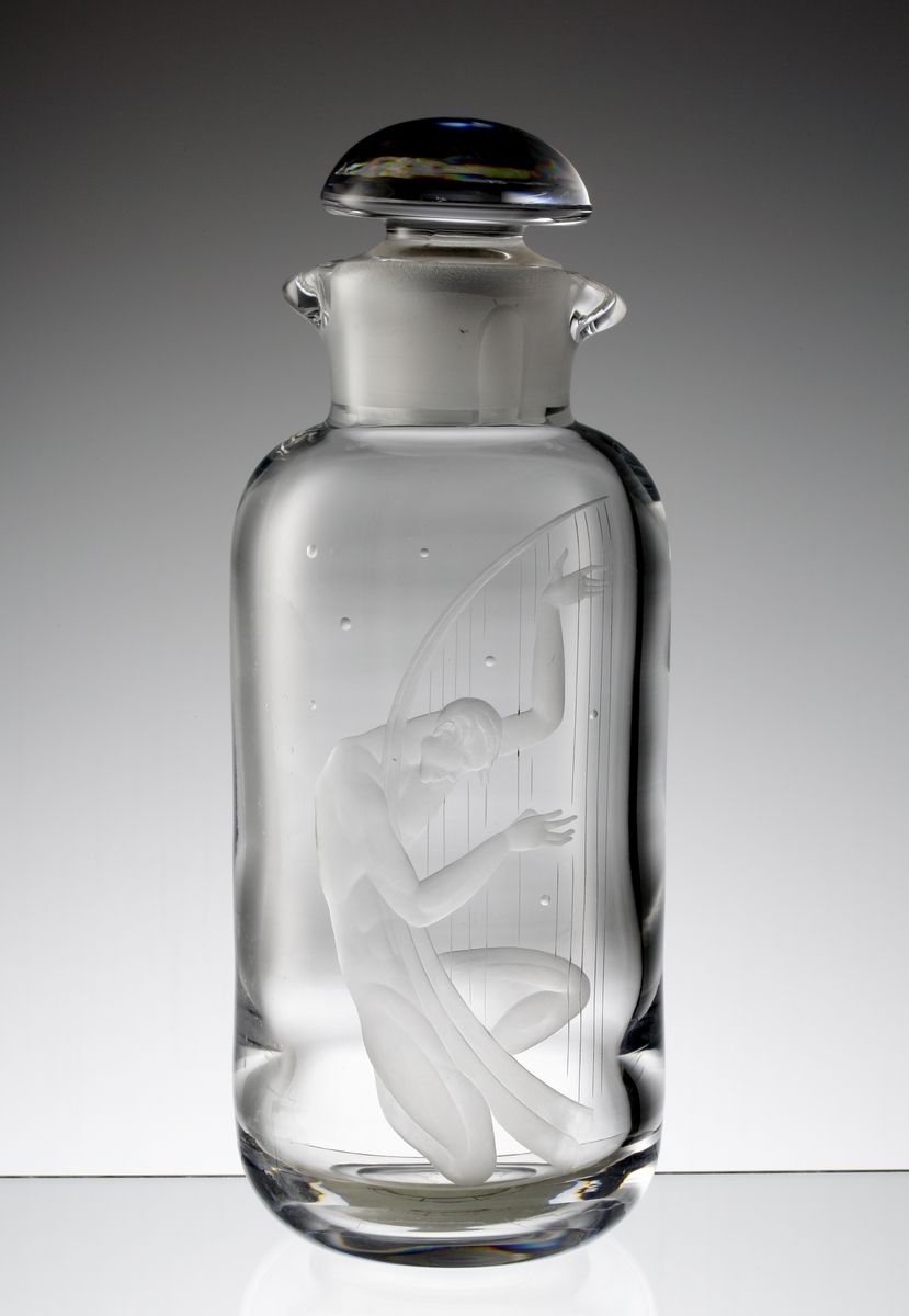 Formgivare: Vicke Lindstrand. Cylindrisk hals med två ispipar. Halvklotsformad propp. Cylindrisk buk med rundat axelparti. Graverat motiv av mansfigur med harpa.
Gravör: John Rosenstam, verksam vid bruket 1923-62.