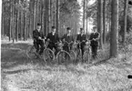 Fyra unga män med cyklar framför en gles tallskog. En av dem är Oscar Johansson från Ebbarp, Lekeryd.