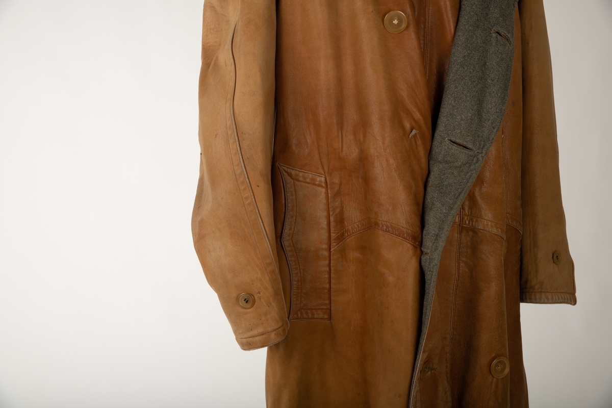 Dobbeltspennet frakk i lær og tweed. Frakken er sydd slik at den kan vrenges og brukes enten som en lærfrakk med foring av tweed eller en frakk av tweed med foring av lær. Begge sidene har opprinnelig fem knapper på hver side tillegg til to ved kragen, men lærsiden mangler en knapp på hver side. Begge har lommer med klaffer, en på høyre og en på venstre side. Begge har en splitt nederst på baksiden som kan kneppes igjen med tre knapper, lærsiden mangler en knapp. En bred krage i halsen er likedan slik at den fungerer på begge sider. I hver ermeende sitter to knapper på ene siden og to på andre, som gjør at ermet kan strammes inn med å feste på et bånd. Dette båndet sitter på siden som vender inn, men kan flyttes på. Et tilsvarende bånd sitter også ved kragen på den siden som vender inn. Det sitter i tillegg et metallhekte i kragen innerst ved halsen.