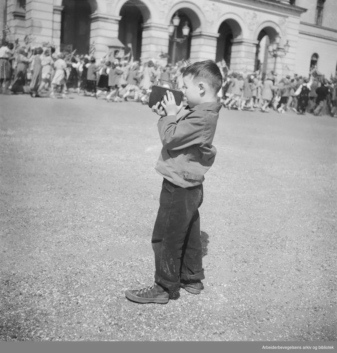 17. mai 1950. Barnetoget. Slottsplassen. Gutt med smalfilmkamera.